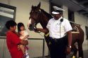 An african american police officer with horse talks to asian children in Cincinnati, Ohio.
