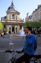A french woman using a cell phone in front of the Sorbonne in Paris, France.