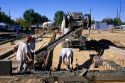 Workers pour ready-mix concrete footings for a new home foundation, Idaho.