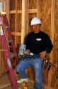 Portrait of a hispanic carpenter wearing a hard hat and holding a nail gun. MR
