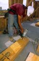 Construction worker using a pneumatic nail gun.