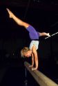 A female gymnast on a balance beam.