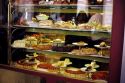 A restaurant display widow showing pastries and sandwiches in Italy.