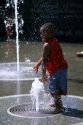 An african american boy plays in a water fountain at the Capital Mall in Nashville, Tennessee.
