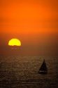 A sailboat at sunset off Huntington Beach in California.