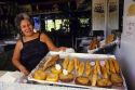 A woman sells fried Puerto Rican food at a sidewalk cafe in Puerto Rico.