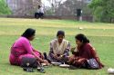 Indian women eating lunch on the grass in India.