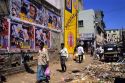 A street scene with movie posters on a wall in Bangalore, India.