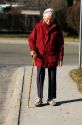 Elderly woman walking with a cane. MR