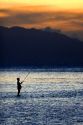 Fishing at sunset in the lagoon off the island of Tahiti.