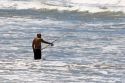 Fisherman surfcasting in the ocean near Miramar Argentina.