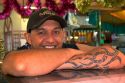 Tahitian man with traditional tatoo on his arm at a market in Papeete on the island of Tahiti.