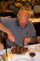 Customer eating a huge t-bonesteak at Estancia a famous restaurant in Buenos Aires,  Argentina.