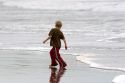 A boy plays in the ocean surf on the beach at Santa Cruz, California.