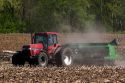 Tractor using the practice of minimum tillage for planting soy beans over last years corn crop near Clarksville, Michigan.