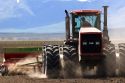 Four wheel drive tractor with dual tires planting wheat in Camas County, Idaho.