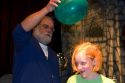 A man demonstrates static electricity with a balloon and girl's hair at the Discovery Center in Little Rock, Arkansas.