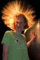 Girl with hair standing on end do to static electricity from a Van de Graaff Generator at the Discovery Center in Little Rock, Arkansas.