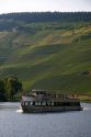 Tour boat on the Mosel River in northwest Germany with vineyards on the hillside.