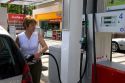 Woman fueling a car at a gas station in Friesing, Germany. MR