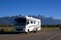 Morning view of Teton Mountains in Grand Teton National Park, Wyoming with a motor home on the road.