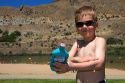 Five year old boy applying sunblock while at the beach. Sandy Point near Boise, Idaho. MR