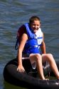 A boy wearing a lifejacket floats the Boise River on a tube. Boise, Idaho.