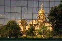 A reflected and distorted view of the capitol building in Des Moines, Iowa in the glass of the Henry A. Wallace office building.