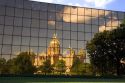 A reflected and distorted view of the capitol building in Des Moines, Iowa in the windows of the Henery A. Wallace office building.