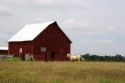 A horse stands in front of a red barn at Macon, Missouri.