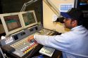 Sound engineer operating commercial broadcast radio control panel in Boise, Idaho. MR