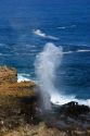 Waves crash through a blow hole on the island of Maui, Hawaii.