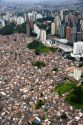 Aerial view of crowded favela housing contrasts with modern apartment buildings in Sao Paulo, Brazil.