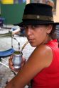 Argentine woman drinking yerba mate out of a silver cup with a straw in the La Boca area of Buenos Aires, Argentina. ( model released)