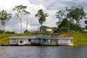 River boat and house on the Arasa River in the Amazon jungle near Manaus, Brazil.
