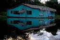 A rustic hotel  reflected in the water on the Arasa River in the Amazon jungle near Manaus, Brazil.