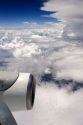 Passenger view of airplane jet engine and clouds.