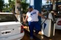 Man pumping gas at a gas station in Argentina.