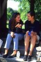 Female german students talking and having lunch in a park.