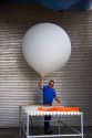 Meteorologist launching a weather balloon with a radiosonde sensor at the National Weather Service in Boise, Idaho.