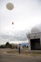 Meteorologist launching a weather balloon with a radiosonde sensor at the National Weather Service in Boise, Idaho.