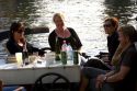 People dine and relax along the Amstel River in Amsterdam, Netherlands.