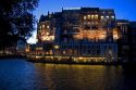 The Hotel de L'Europe at night along the Amstel River in Amsterdam, Netherlands.
