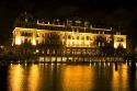 The Amset Hotel with lights at night along the Amstel River in Amsterdam, Netherlands.