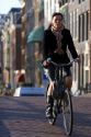 Woman riding a bicycle on the street in Amsterdam, Netherlands.