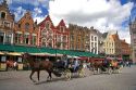 Horse drawn carriages in The Big Market Square at Bruges in the province of West Flanders, Belgium.