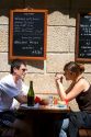 A young couple in love dine at a sidewalk cafe in Saint-Malo in Brittany, northwestern France.