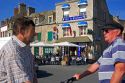 French men talking on the street in the village of Barfleur in the region of Basse-Normandie, France.