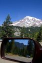 Mt. Rainier in Mt. Rainier National Park, Washington with Cascade Range and highway reflected in automobile mirror.