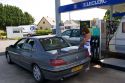 A woman fueling up her car at a gas station in Bayeux in the region of Basse-Normandie, Normandy, France.